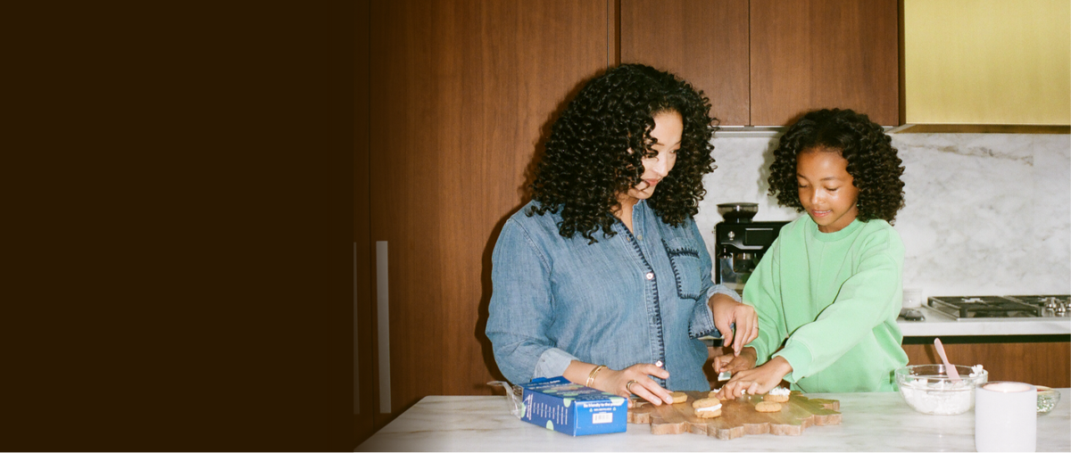 partake founder and her daughter in a kitchen preparing cookies together.